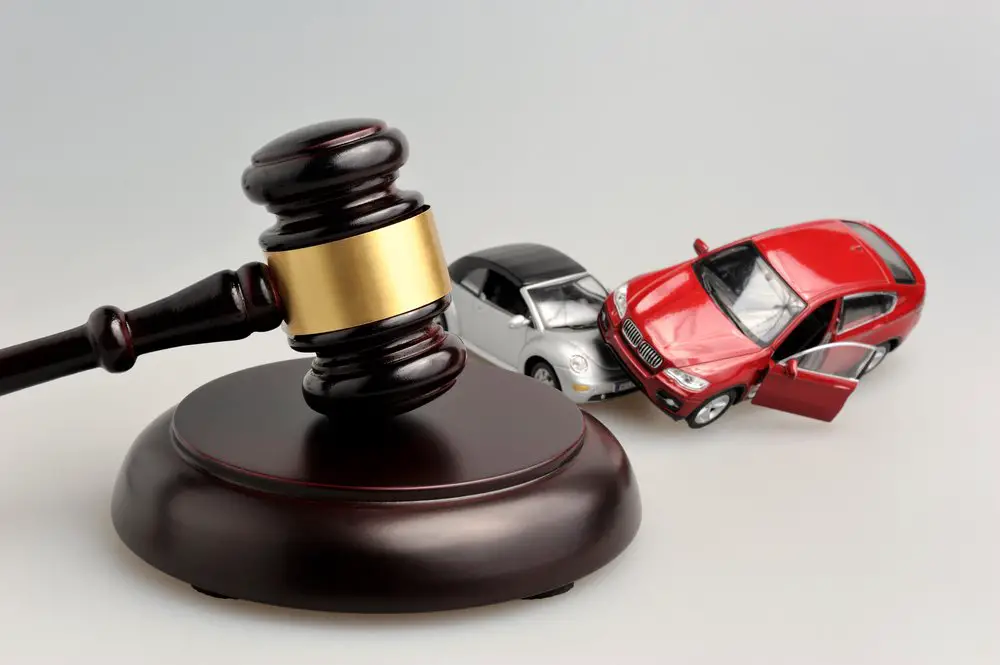 Gavel,judge,with,models,of,car,accident,on,gray,background